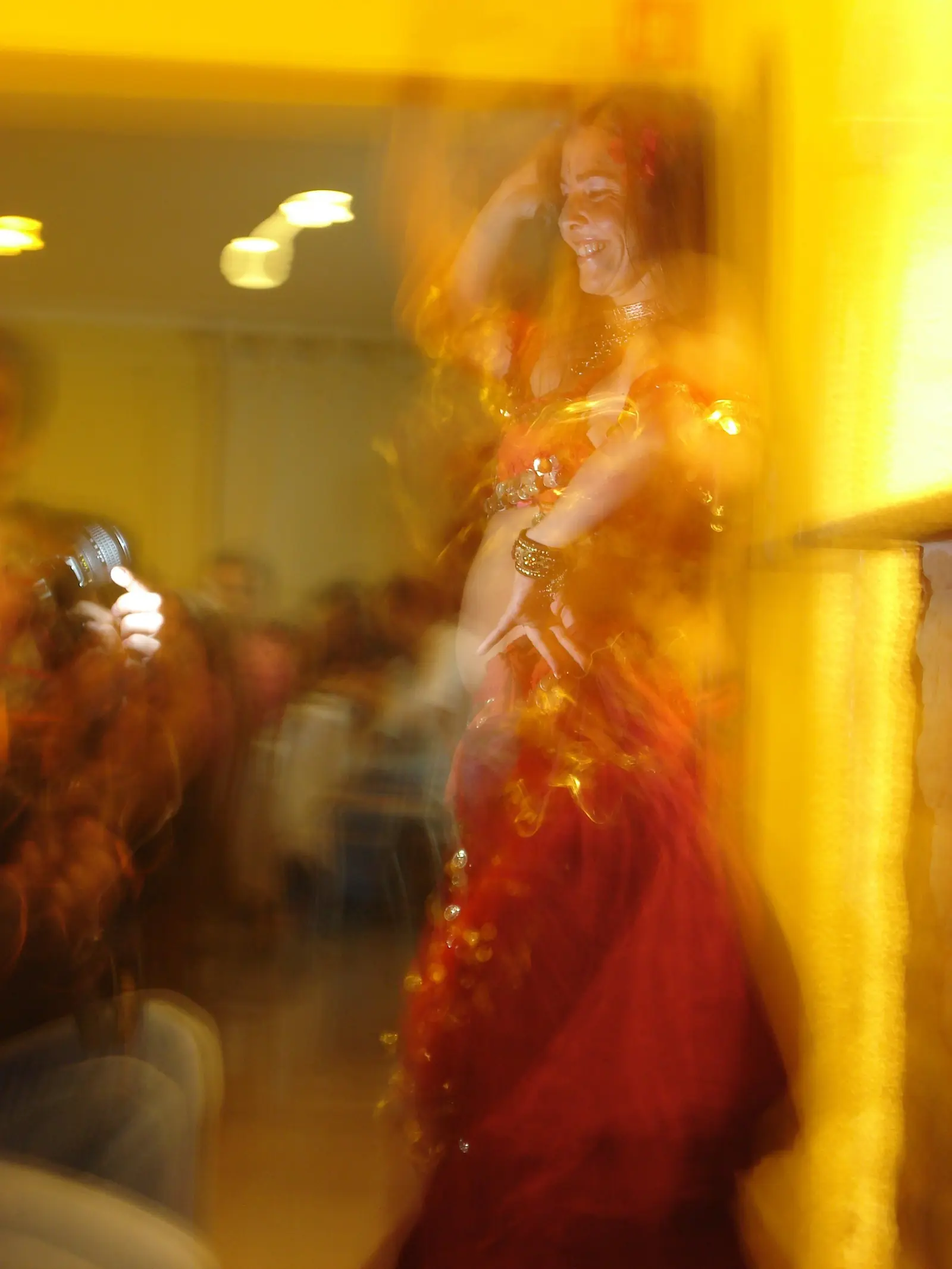 Ana in motion, smiling, in a red coin costume