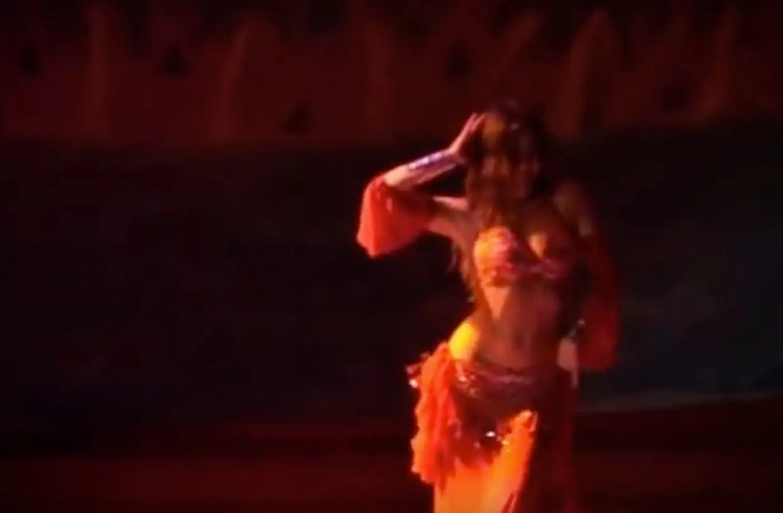 Ana on stage in a red costume, under red light