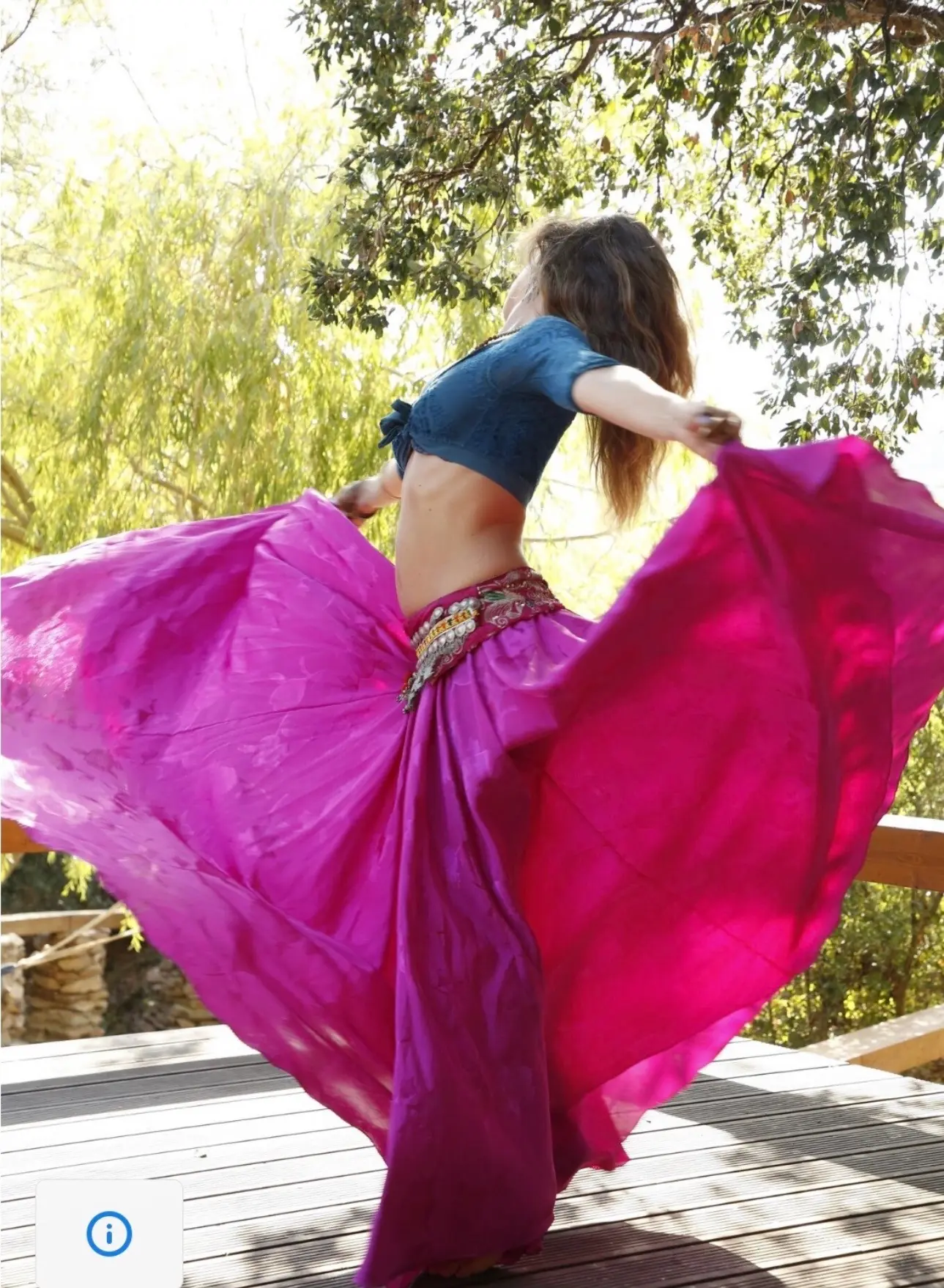 Ana spins on a wooden deck as her fuchsia skirt flares out